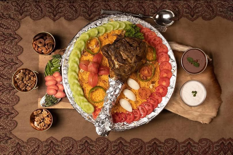 Mandi Platter with a lamb meat piece nuts sauces and plenty of tomatoes and cucumbers royal Arabian restaurant Dubai